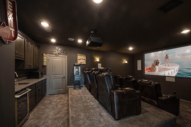 carpeted cinema with visible vents, a sink, baseboards, and recessed lighting