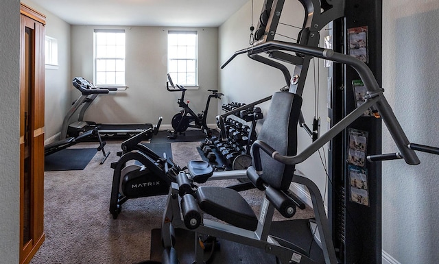 exercise area with baseboards and a textured wall