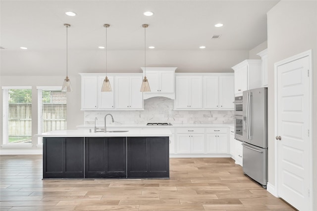 8106 Triumph Bend Way, Magnolia, TX 77354 - kitchen with white cabinets, appliances with stainless steel finishes, a sink, light countertops, and light wood-type flooring