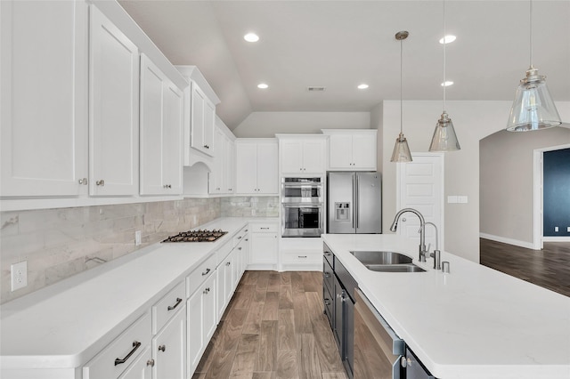 8106 Triumph Bend Way, Magnolia, TX 77354 - kitchen with a kitchen island with sink, appliances with stainless steel finishes, dark wood finished floors, a sink, and light countertops
