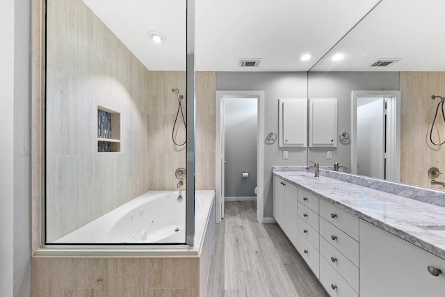 bathroom featuring double vanity, toilet, visible vents, and wood finished floors
