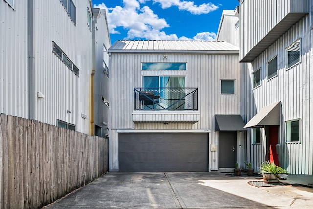 exterior space with an attached garage, fence, and concrete driveway