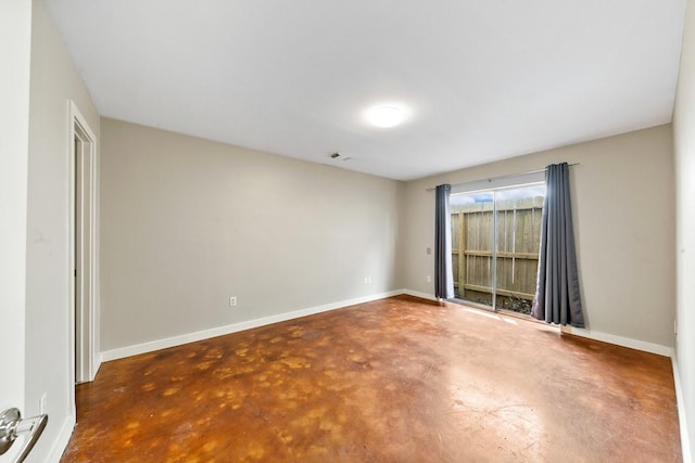 unfurnished room featuring baseboards, concrete floors, and visible vents