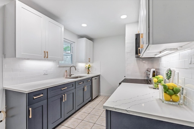 kitchen with a sink, decorative backsplash, stainless steel appliances, and white cabinets