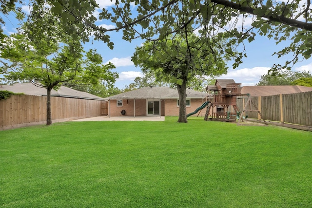 view of yard featuring a fenced backyard, a patio area, and a playground