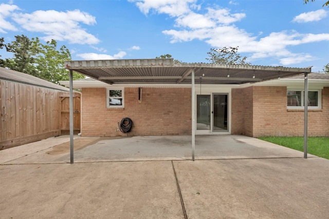 rear view of house with brick siding and fence