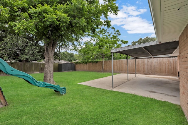 view of yard featuring a storage shed, a playground, a fenced backyard, and a patio area