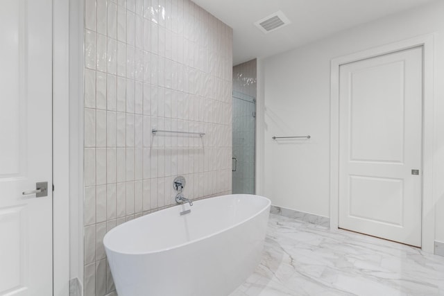 bathroom featuring visible vents, marble finish floor, baseboards, a freestanding bath, and a stall shower
