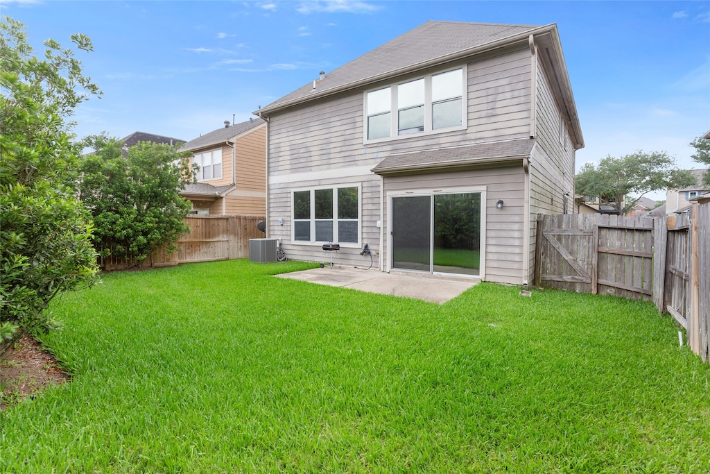 back of house featuring a yard, central AC, a fenced backyard, and a patio area