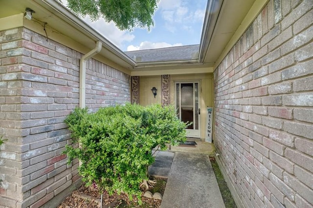 property entrance with brick siding and a shingled roof