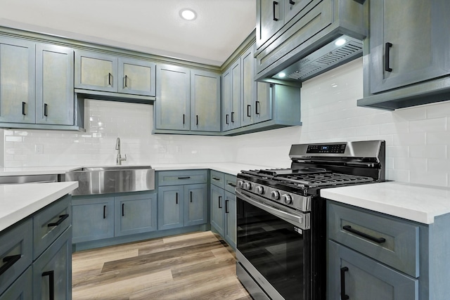 5134 Breckenridge Dr, Houston, TX 77066 - kitchen featuring extractor fan, a sink, decorative backsplash, and stainless steel gas range oven