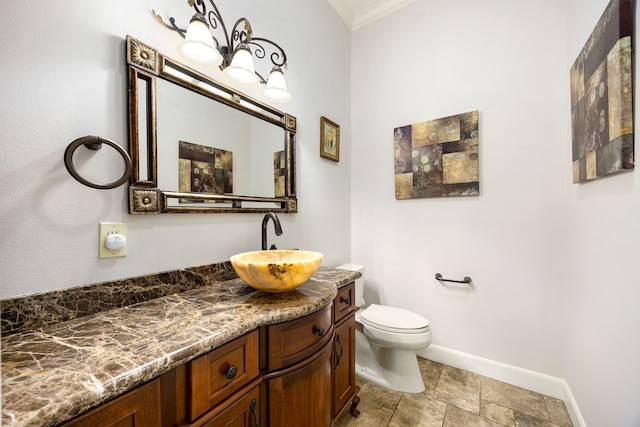 bathroom featuring vanity, toilet, a chandelier, baseboards, and ornamental molding