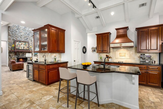 kitchen with visible vents, a sink, beamed ceiling, beverage cooler, and custom range hood