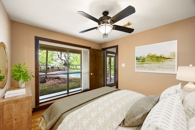 bedroom with ceiling fan, visible vents, and wood finished floors
