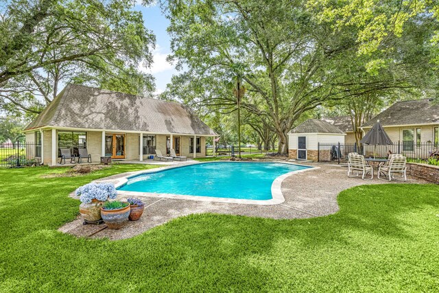view of swimming pool featuring fence, a patio, an exterior structure, a fenced in pool, and an outbuilding