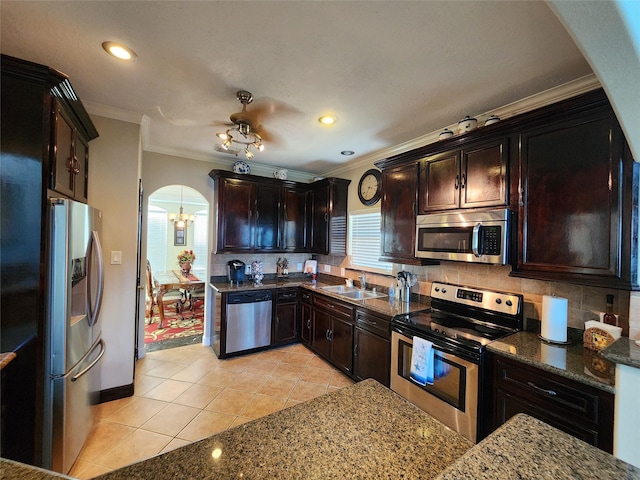 231 Key Largo Loop, Point Blank, TX 77364 - kitchen with crown molding, a sink, light tile patterned flooring, arched walkways, and appliances with stainless steel finishes