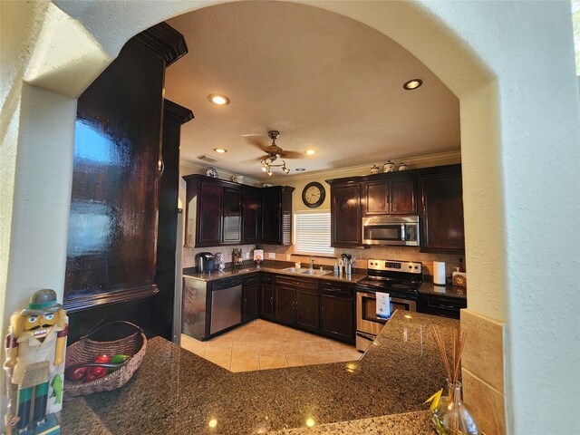 231 Key Largo Loop, Point Blank, TX 77364 - kitchen featuring dark brown cabinetry, a ceiling fan, arched walkways, a sink, and stainless steel appliances