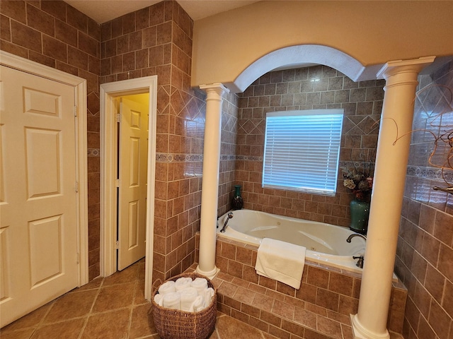 231 Key Largo Loop, Point Blank, TX 77364 - bathroom with a garden tub, decorative columns, tile patterned flooring, and tile walls