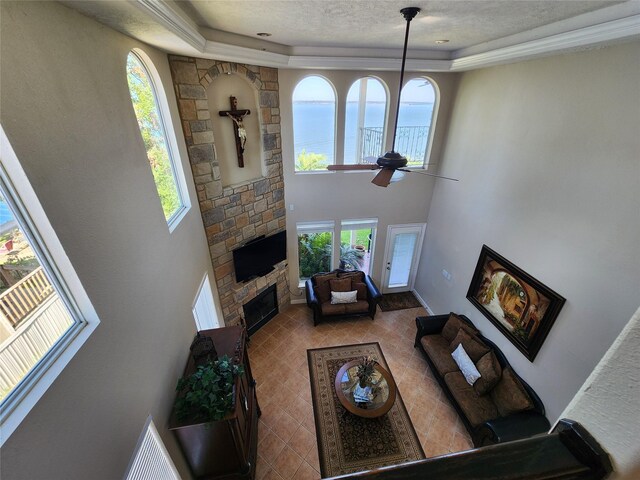 231 Key Largo Loop, Point Blank, TX 77364 - living area with a glass covered fireplace, a ceiling fan, a tray ceiling, and a towering ceiling