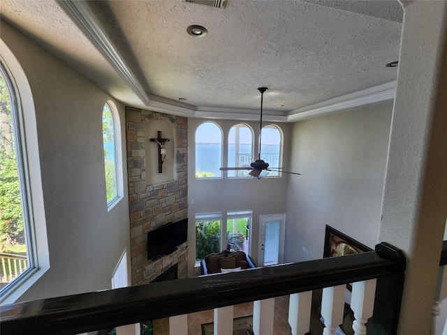 231 Key Largo Loop, Point Blank, TX 77364 - interior space with ceiling fan, a fireplace, a textured ceiling, plenty of natural light, and a tray ceiling