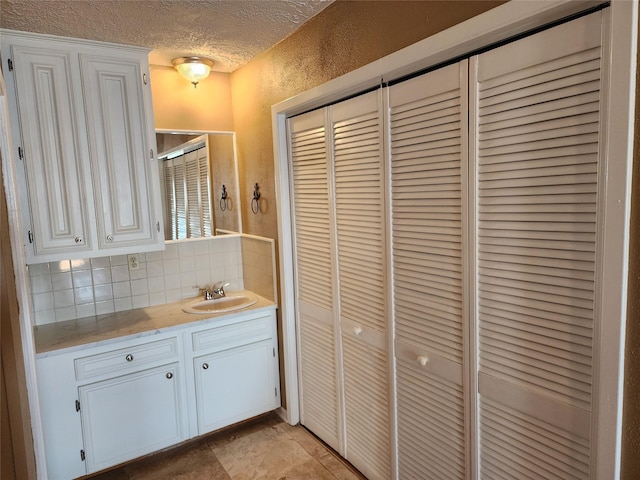 398 Lakeshore S, Onalaska, TX 77360 - bathroom featuring a closet, vanity, a textured ceiling, tasteful backsplash, and a stall shower
