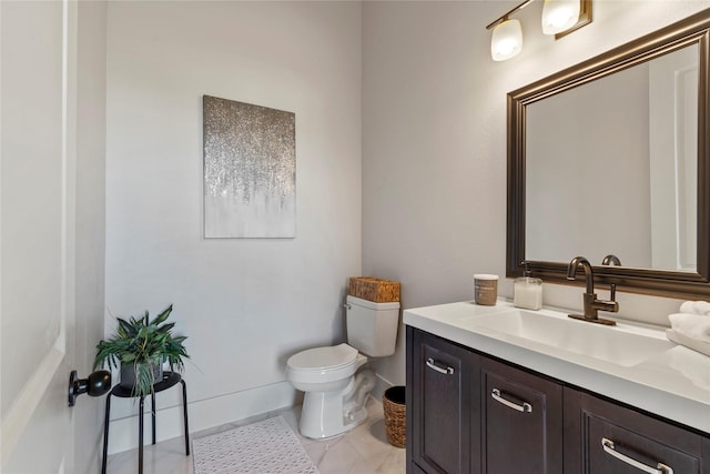 bathroom with vanity, baseboards, and toilet