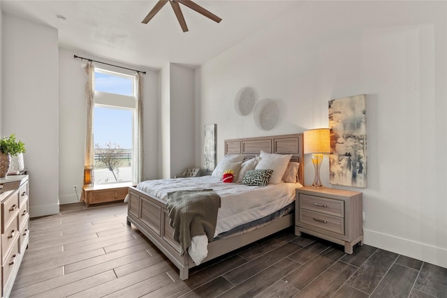 bedroom with baseboards, multiple windows, and dark wood-type flooring