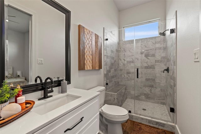 ensuite bathroom with vanity, a stall shower, ensuite bath, and toilet