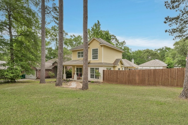back of property featuring fence, a patio, a shingled roof, and a lawn
