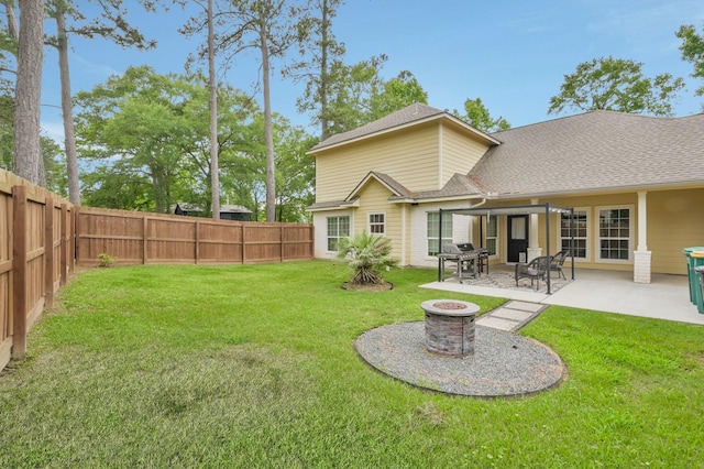 back of house with a lawn, a fenced backyard, an outdoor fire pit, and a shingled roof