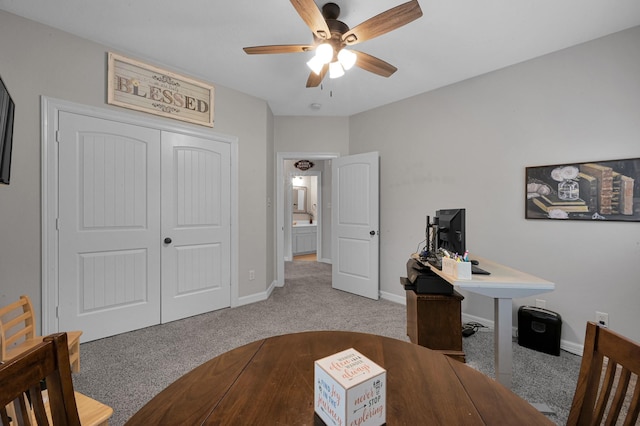 home office featuring a ceiling fan, baseboards, and dark carpet