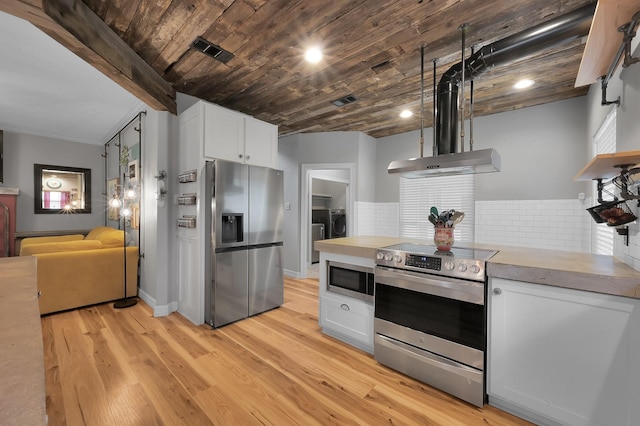 kitchen with white cabinets, appliances with stainless steel finishes, light wood-style floors, visible vents, and washing machine and dryer