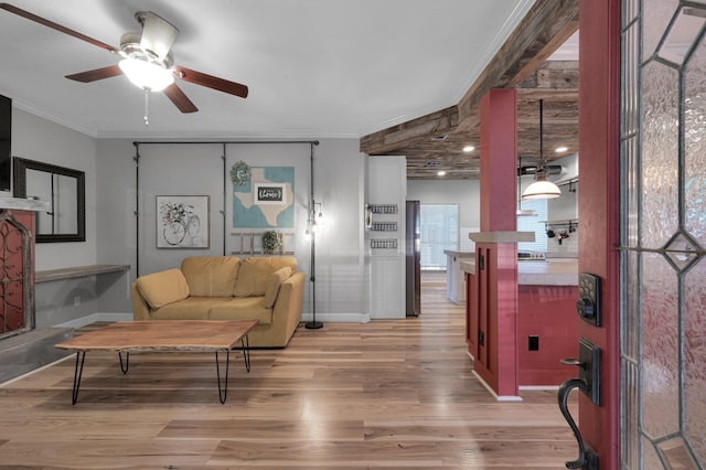 living area with light wood-type flooring, ornamental molding, and ceiling fan