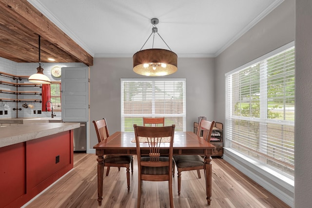 dining space with crown molding and light wood-style floors