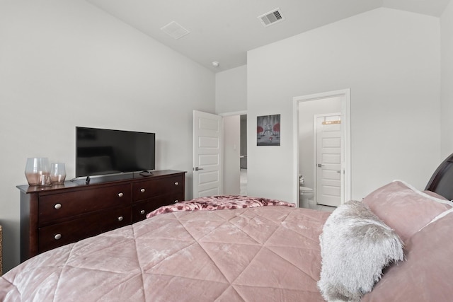 bedroom with visible vents, ensuite bathroom, and high vaulted ceiling