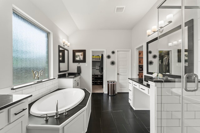 full bathroom featuring vanity, a shower stall, a spacious closet, visible vents, and a bath