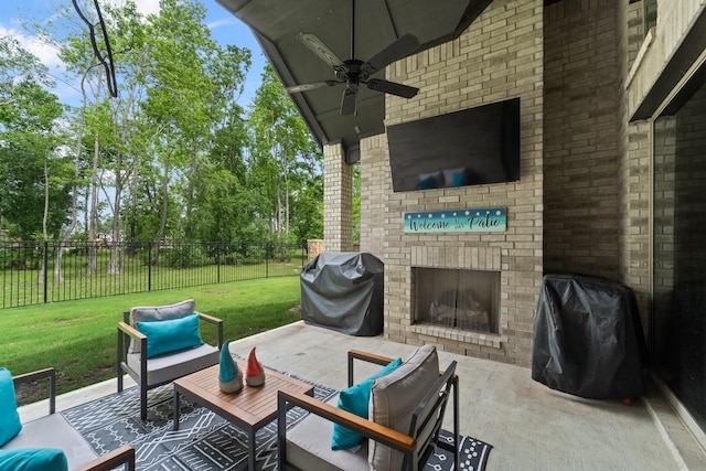 view of patio with ceiling fan, an outdoor living space with a fireplace, fence, and area for grilling