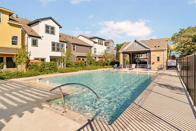 pool with a patio, a gazebo, fence, and a residential view