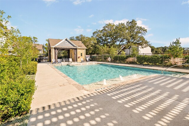 pool with a patio area and fence