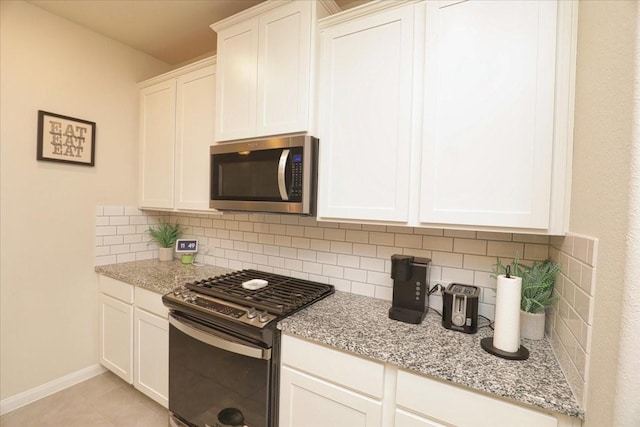 kitchen with decorative backsplash, gas range, white cabinetry, stainless steel microwave, and light stone counters