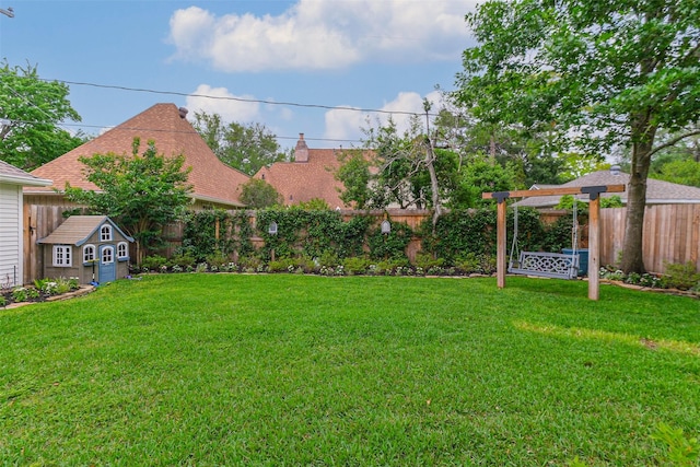 view of yard with a fenced backyard, a shed, and an outbuilding
