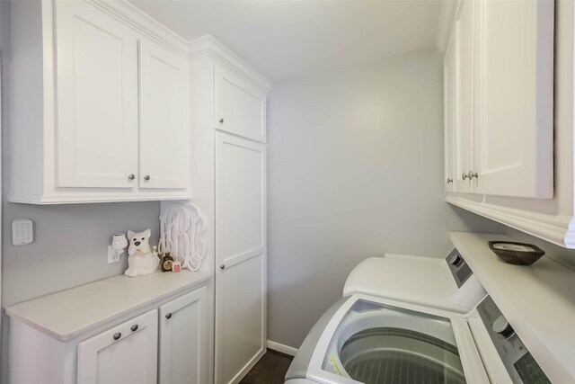 laundry room featuring baseboards, cabinet space, and washer / clothes dryer