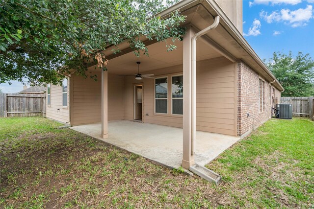 back of house featuring brick siding, a fenced backyard, a ceiling fan, a patio, and a yard