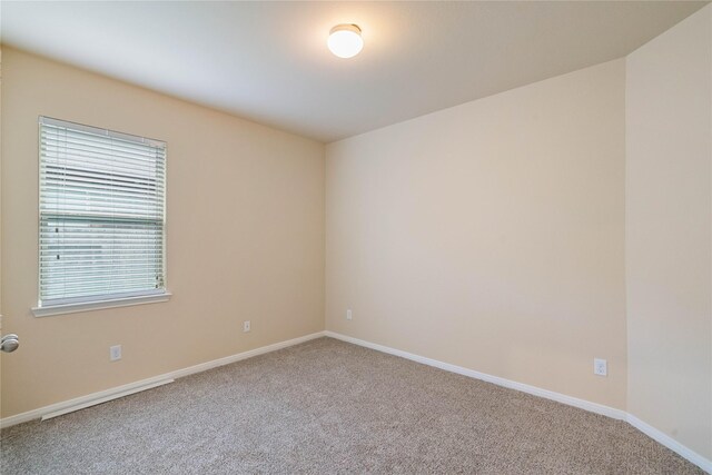 empty room featuring carpet flooring and baseboards