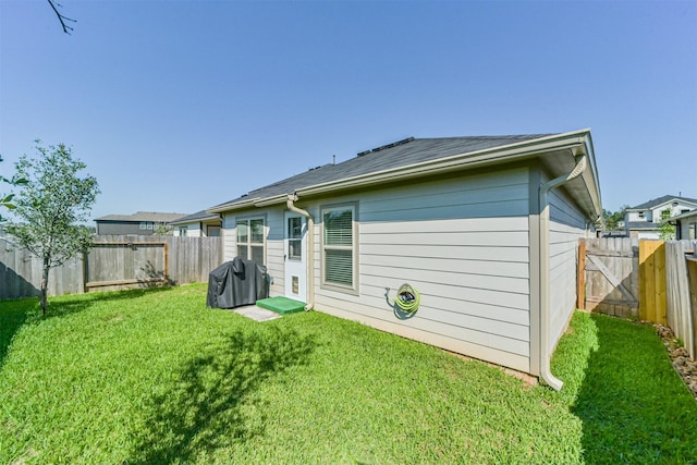 back of property featuring a lawn and a fenced backyard