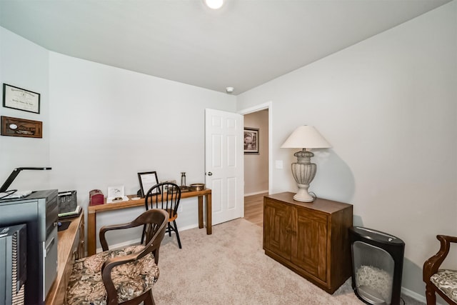 office space featuring baseboards and light carpet