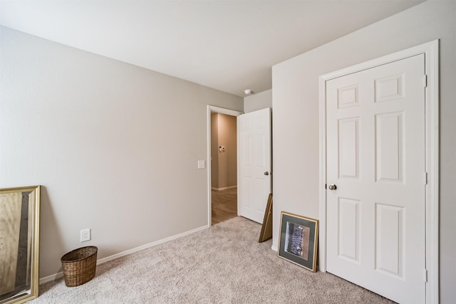 unfurnished bedroom with baseboards and light carpet