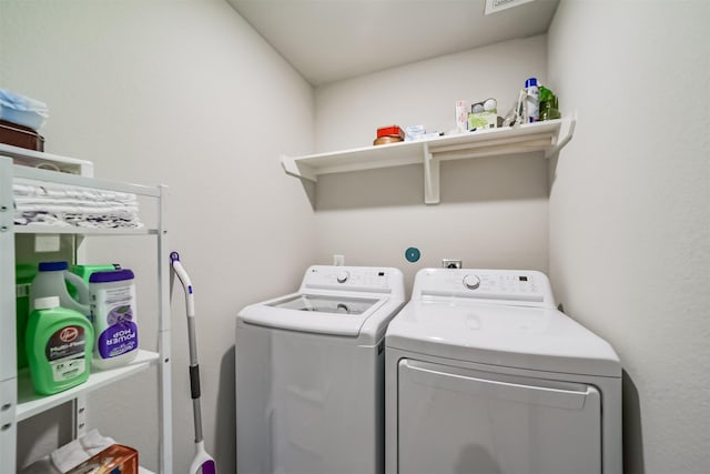 washroom featuring laundry area, washing machine and dryer, and visible vents