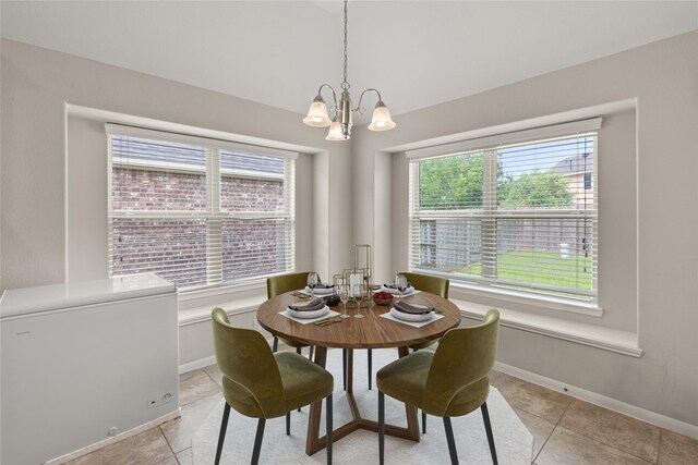 dining room featuring baseboards, light tile patterned flooring, and a notable chandelier