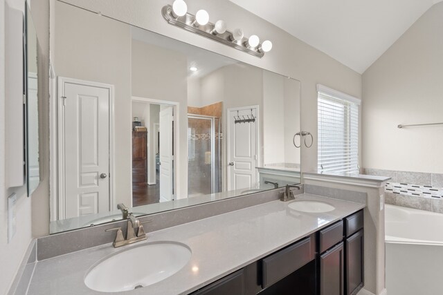 bathroom featuring double vanity, a sink, a garden tub, and a stall shower
